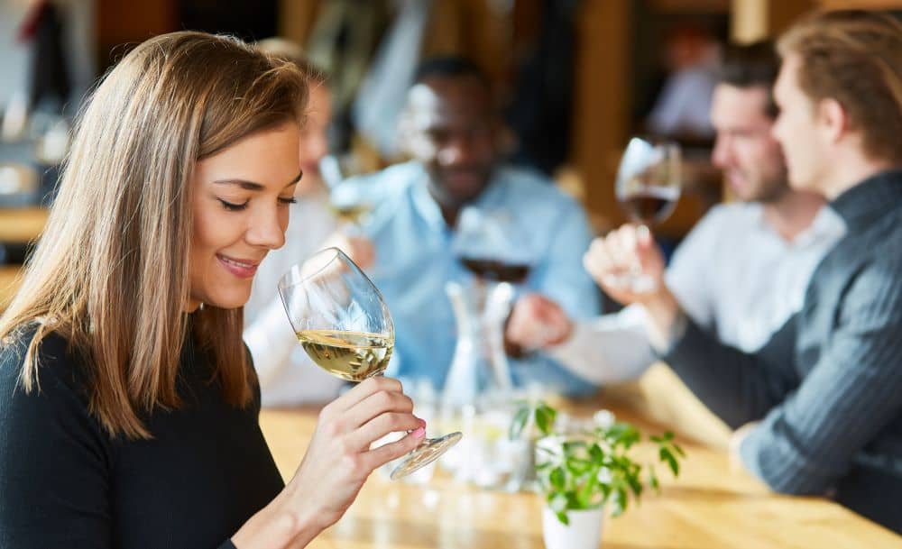 A woman tasting wine.